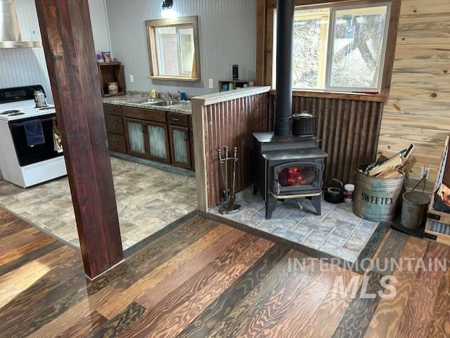 820 Sweeney Road Elk City, ID 83525 - Photo 6 of 45 Detailed view of electric range, extractor fan, wood finished floors, and a wood stove