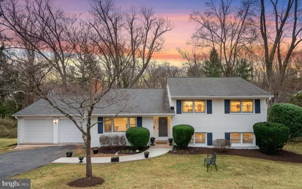a front view of house with yard and trees in the background