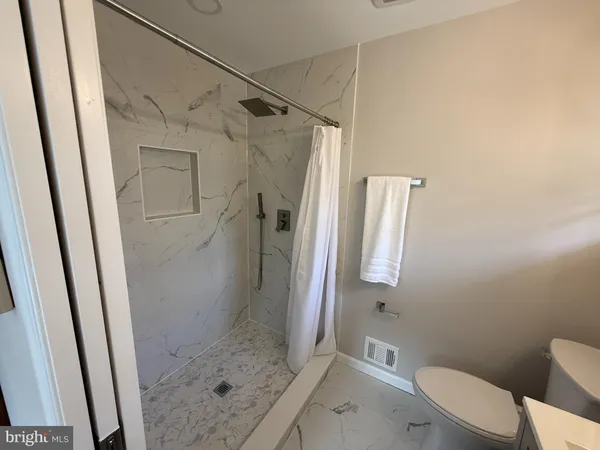 a bathroom with a shower a toilet and a sink