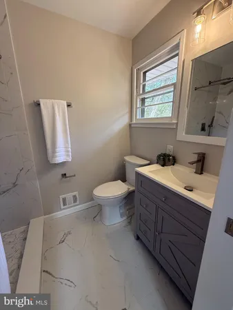 a bathroom with a sink mirror and toilet