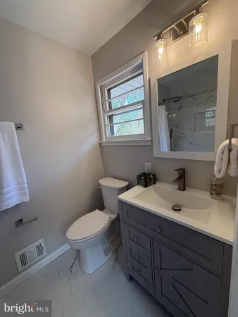 a bathroom with a toilet sink and mirror