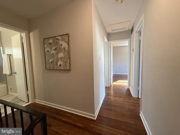 a view of a hallway with wooden floor and stairs