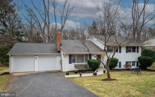 a front view of house with yard and trees in the background