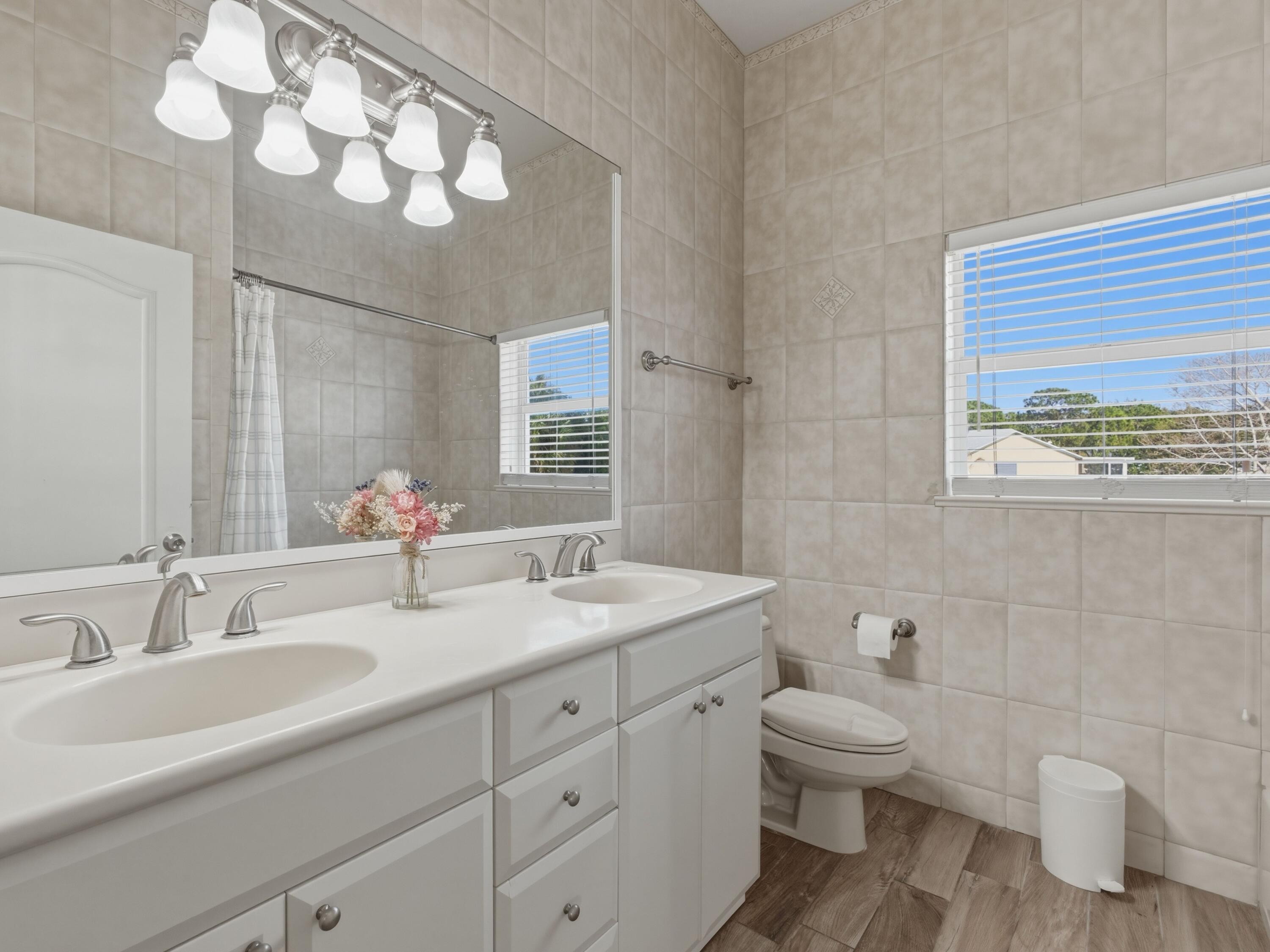 18852 43rd Road North The Acreage, FL 33470 - Photo 17 of 24 a bathroom with a toilet sink and mirror