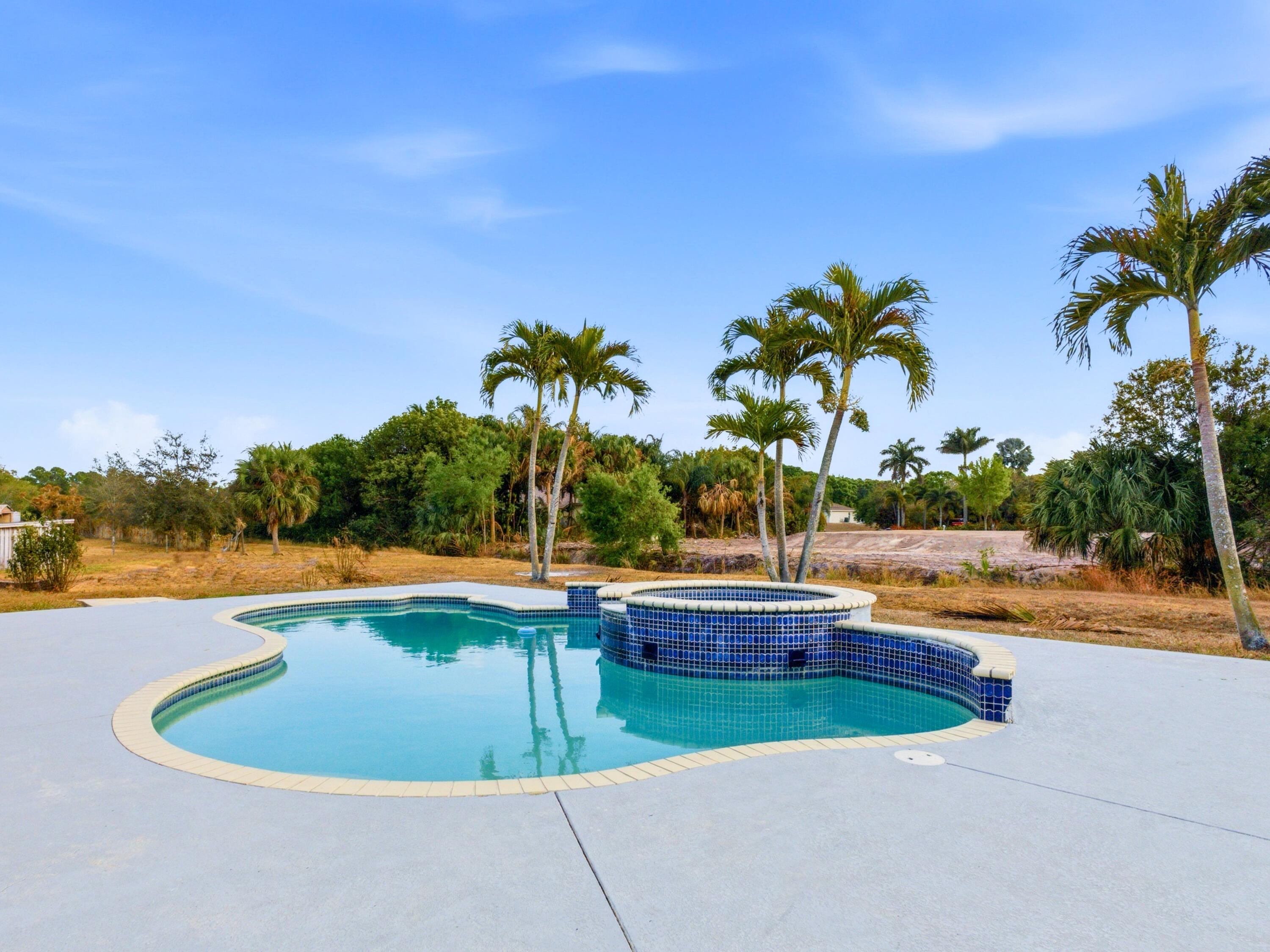 18852 43rd Road North The Acreage, FL 33470 - Photo 20 of 24 a view of a swimming pool and lounge chair