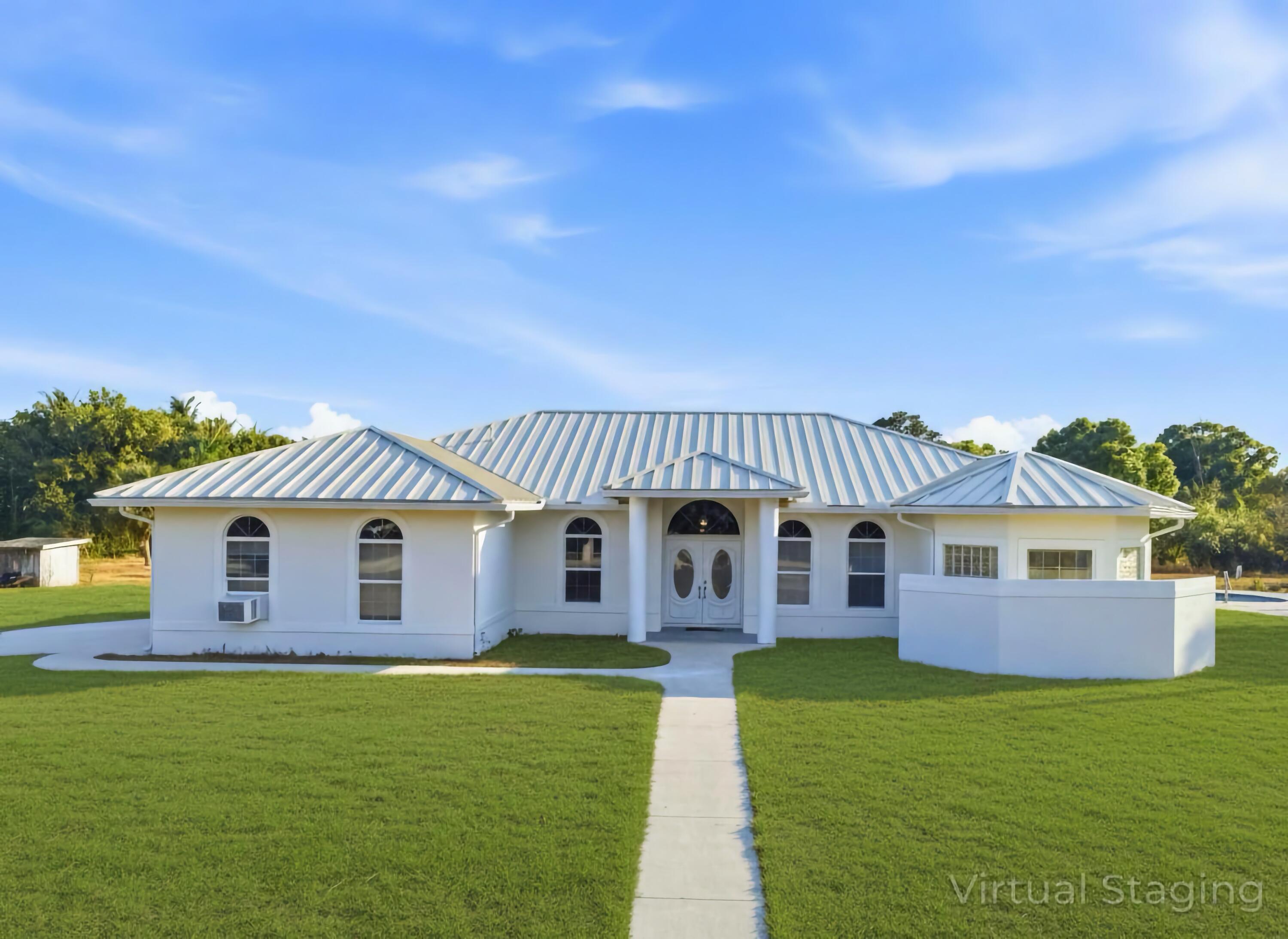 18852 43rd Road North The Acreage, FL 33470 - Photo 2 of 24 a front view of a house with garden