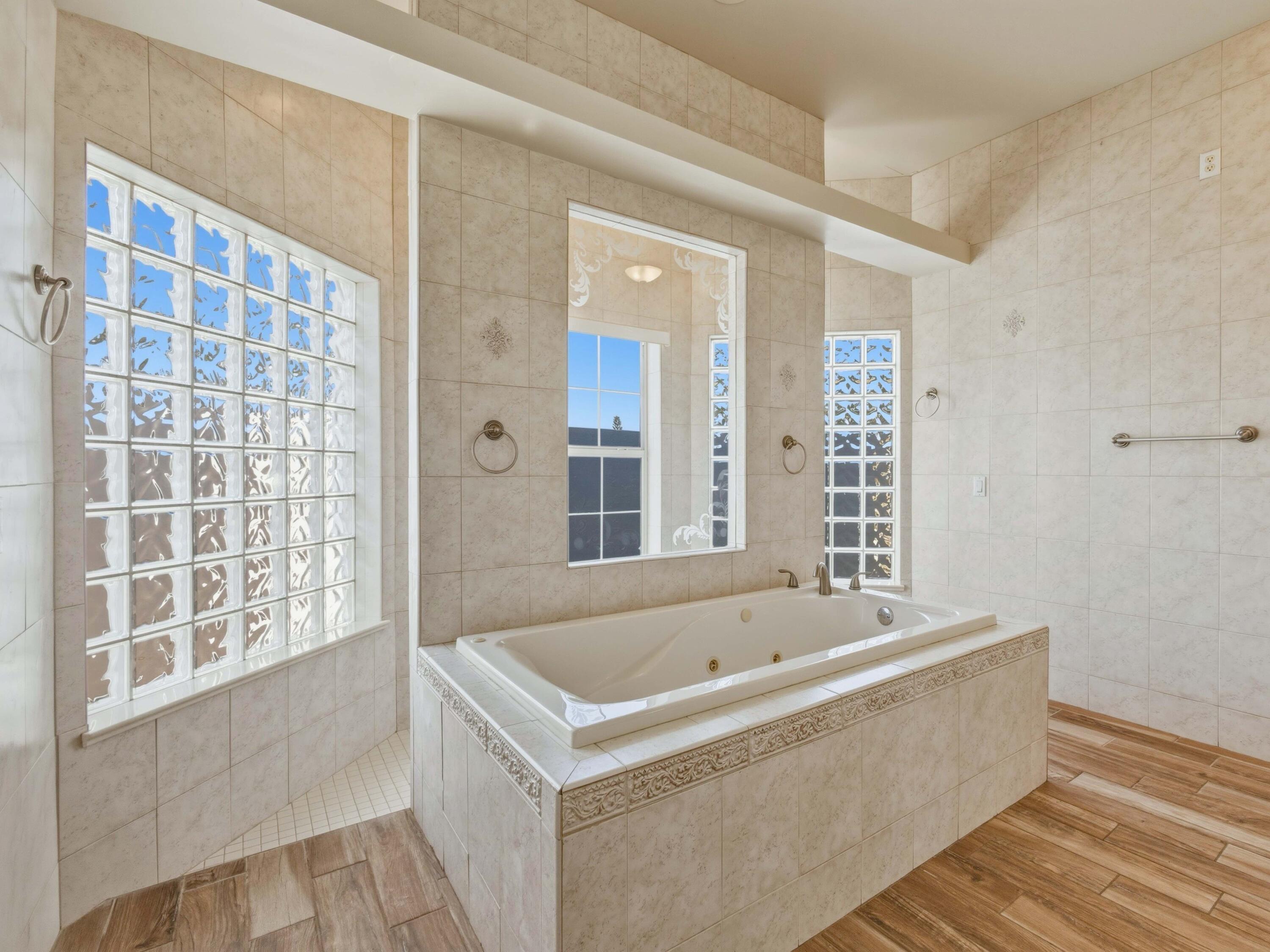 18852 43rd Road North The Acreage, FL 33470 - Photo 10 of 24 a white bath tub sitting in a bathroom next to a window