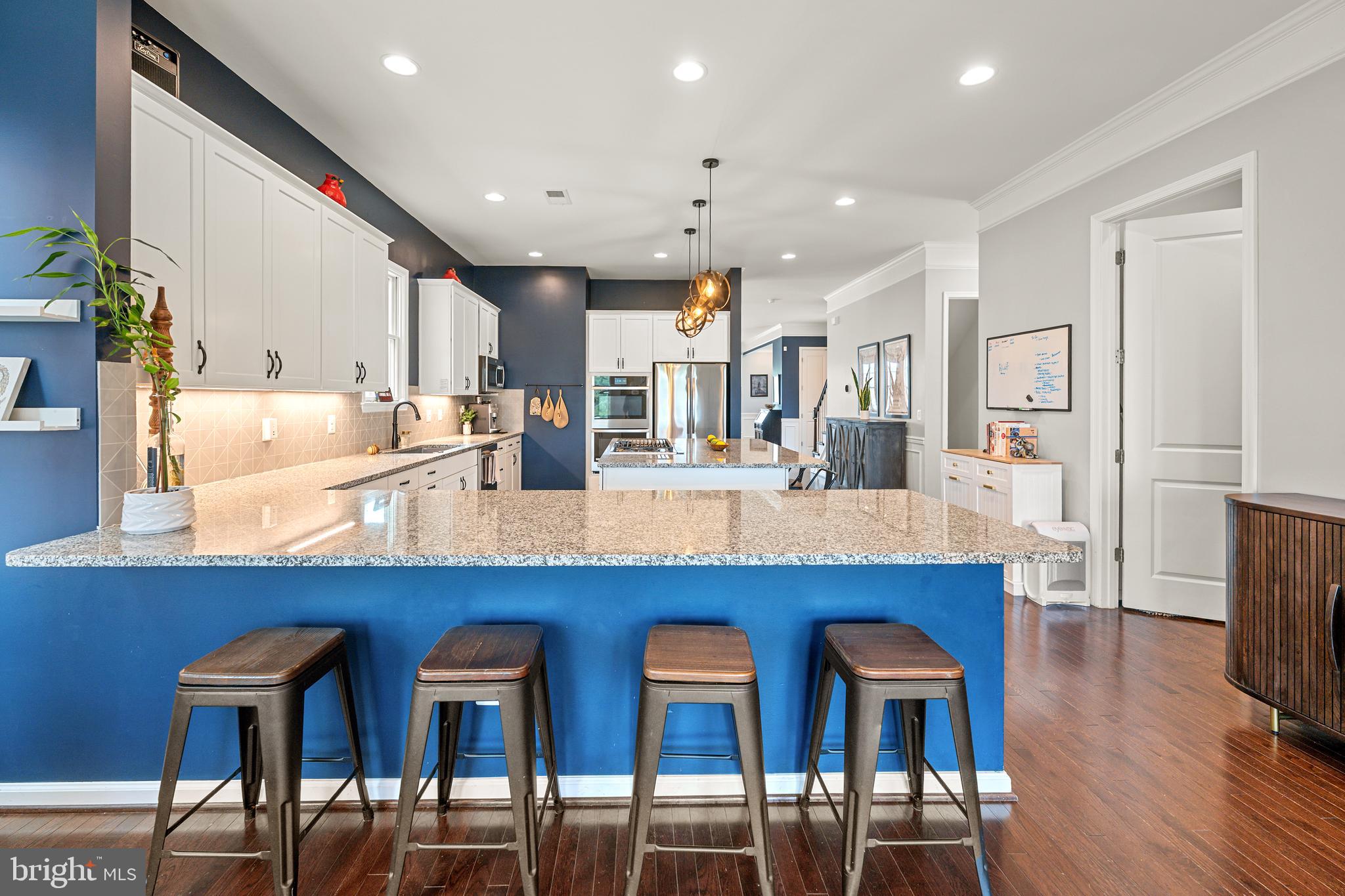 8459 Reformatory Way Lorton, VA 22079 - Photo 17 of 78 a kitchen with stainless steel appliances kitchen island granite countertop a table chairs and wooden floor