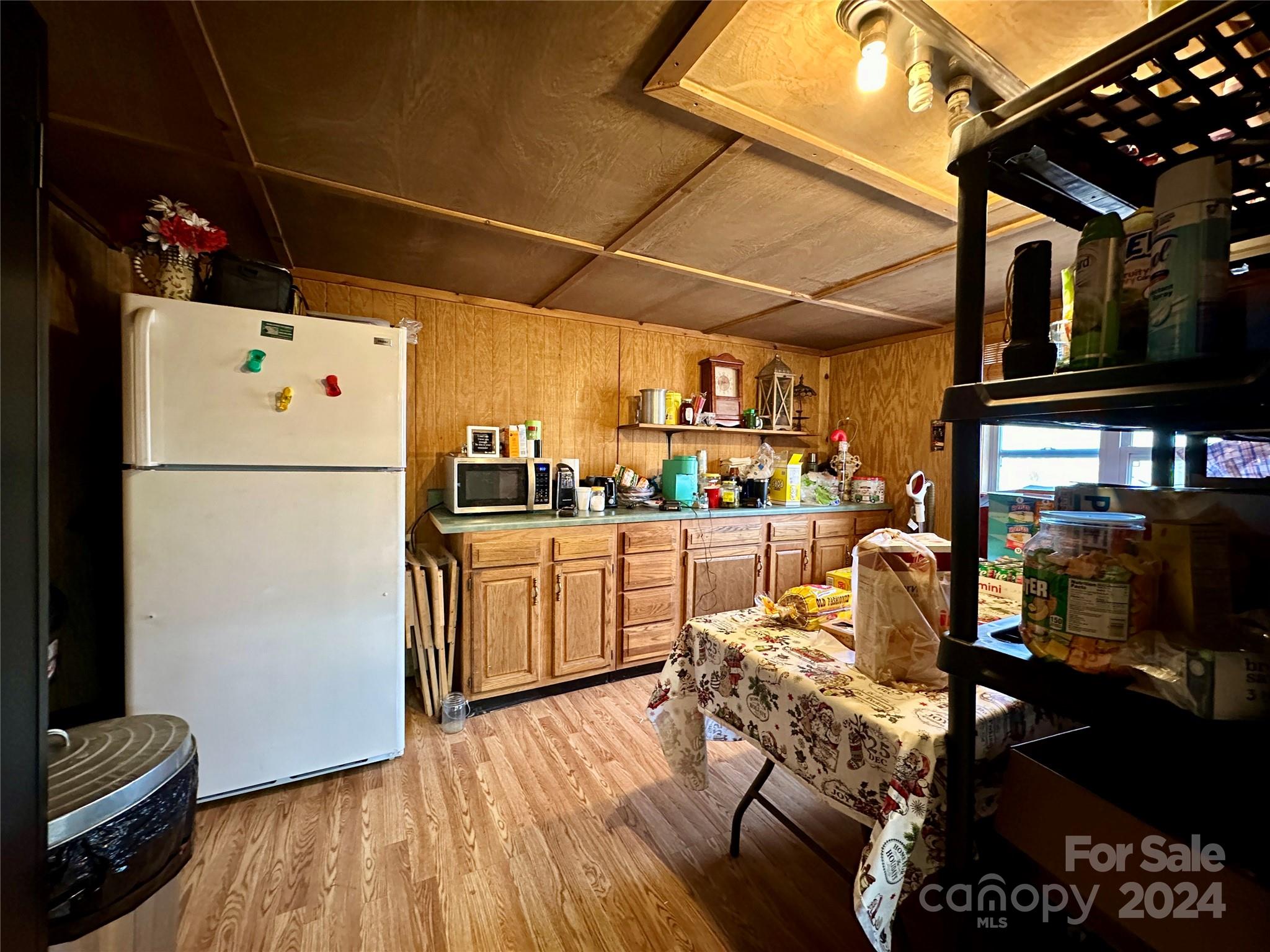 4453 Scott Road Morganton, NC 28655 - Photo 40 of 44 a kitchen with stainless steel appliances granite countertop a refrigerator a sink dishwasher a stove and white countertops with wooden floor