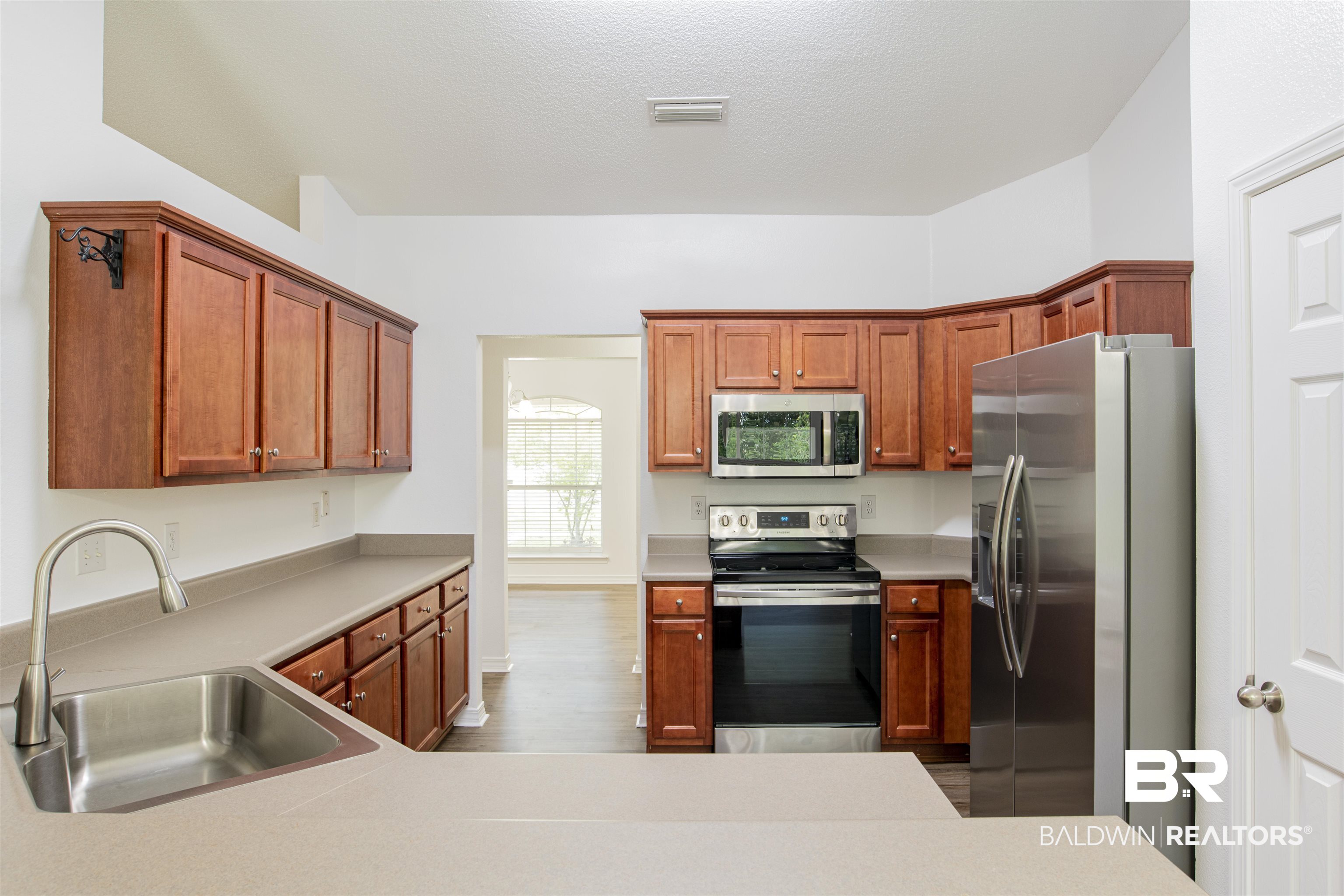 165 Pemberton Loop Fairhope, AL 36532 - Photo 15 of 25 Kitchen featuring light countertops, visible vents, appliances with stainless steel finishes, dark wood-type flooring, and a sink