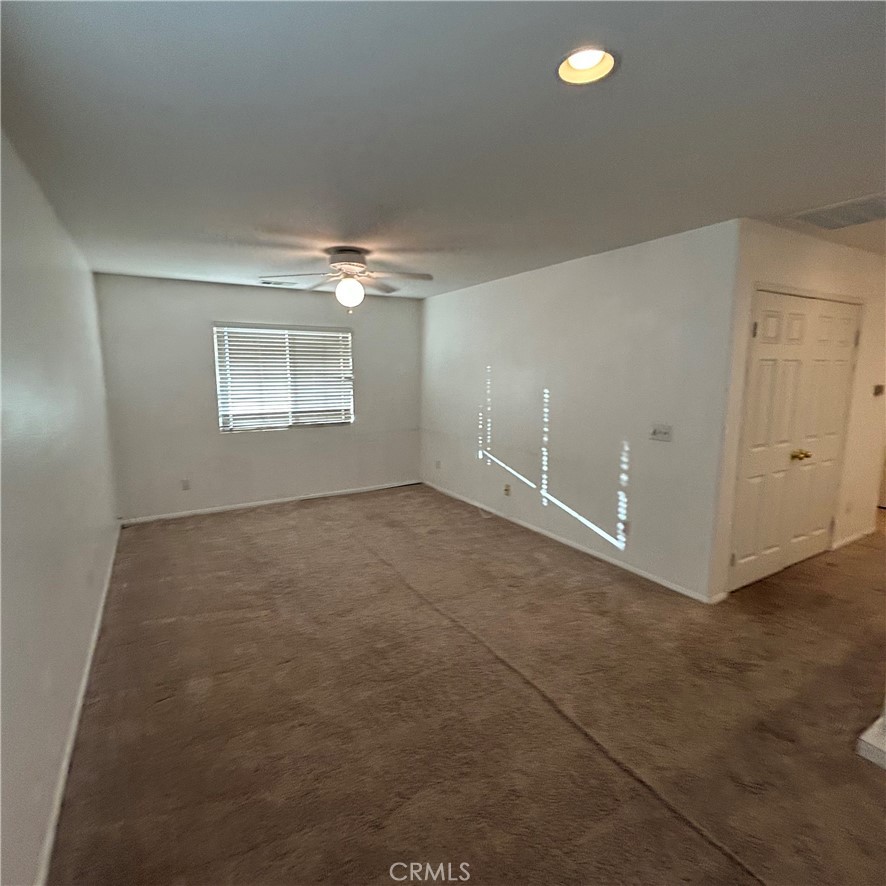 1538 Apple Canyon Road Beaumont, CA 92223 - Photo 9 of 23 en empty room with windows and chandelier fan
