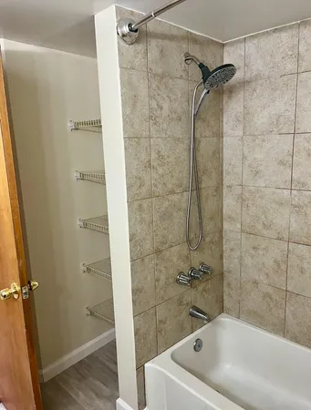 a white bath tub sitting next to a white sink and vanity