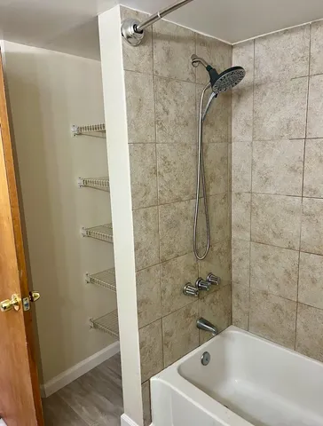 a white bath tub sitting next to a white sink and vanity
