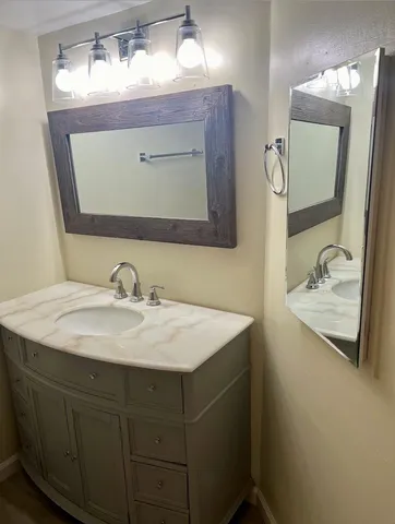 a bathroom with a sink vanity and mirror