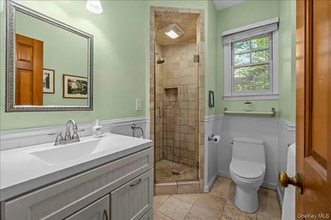 a bathroom with a sink a toilet and shower