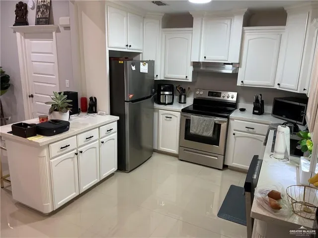 a kitchen with a refrigerator stove and white cabinets