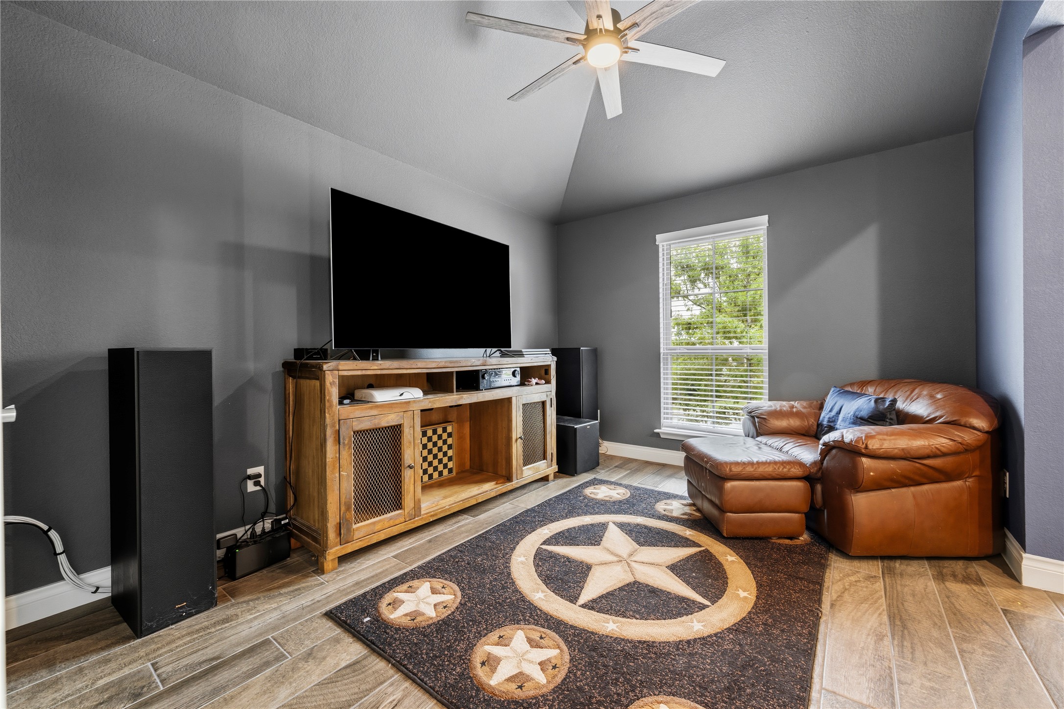140 Catani Loop Georgetown, TX 78628 - Photo 6 of 36 Wood-look tile flooring grounds this inviting family room, where vaulted ceilings crown a spacious entertainment setup.