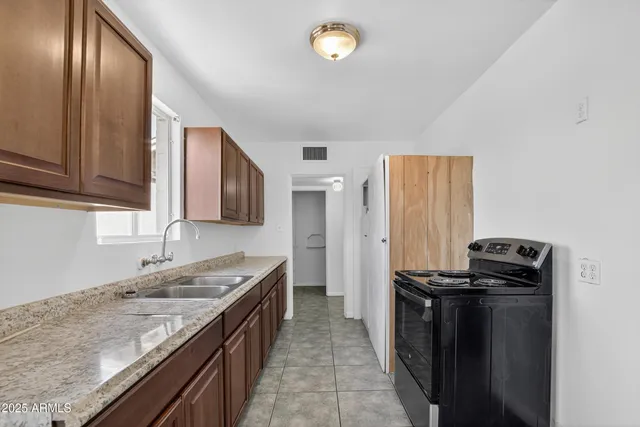 a kitchen with granite countertop stainless steel appliances a sink stove and refrigerator