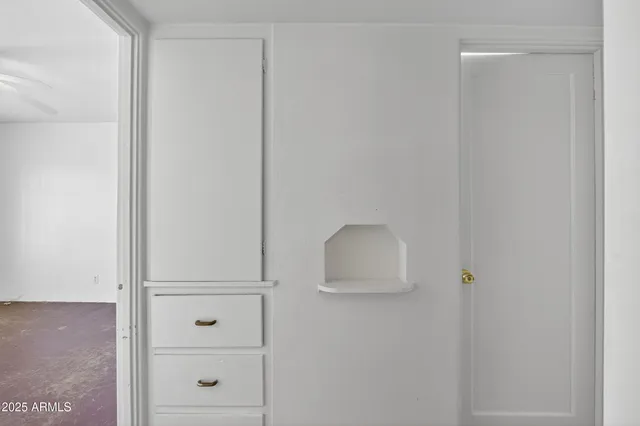 an empty room with a ceiling fan and a window