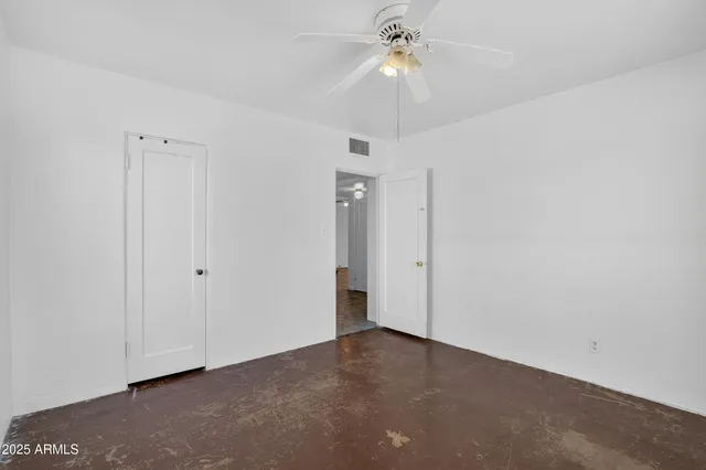 a view of an empty room with chandelier fan