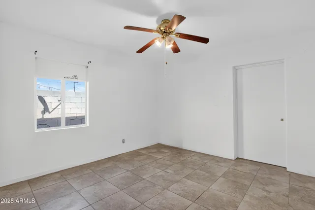 a view of an empty room and chandelier fan