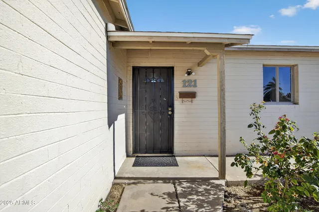 a view of a livingroom with a chandelier fan and kitchen