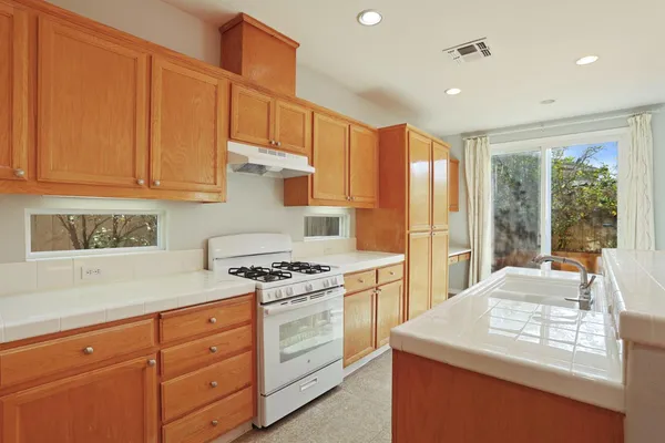 a kitchen with granite countertop cabinets stainless steel appliances and a counter space