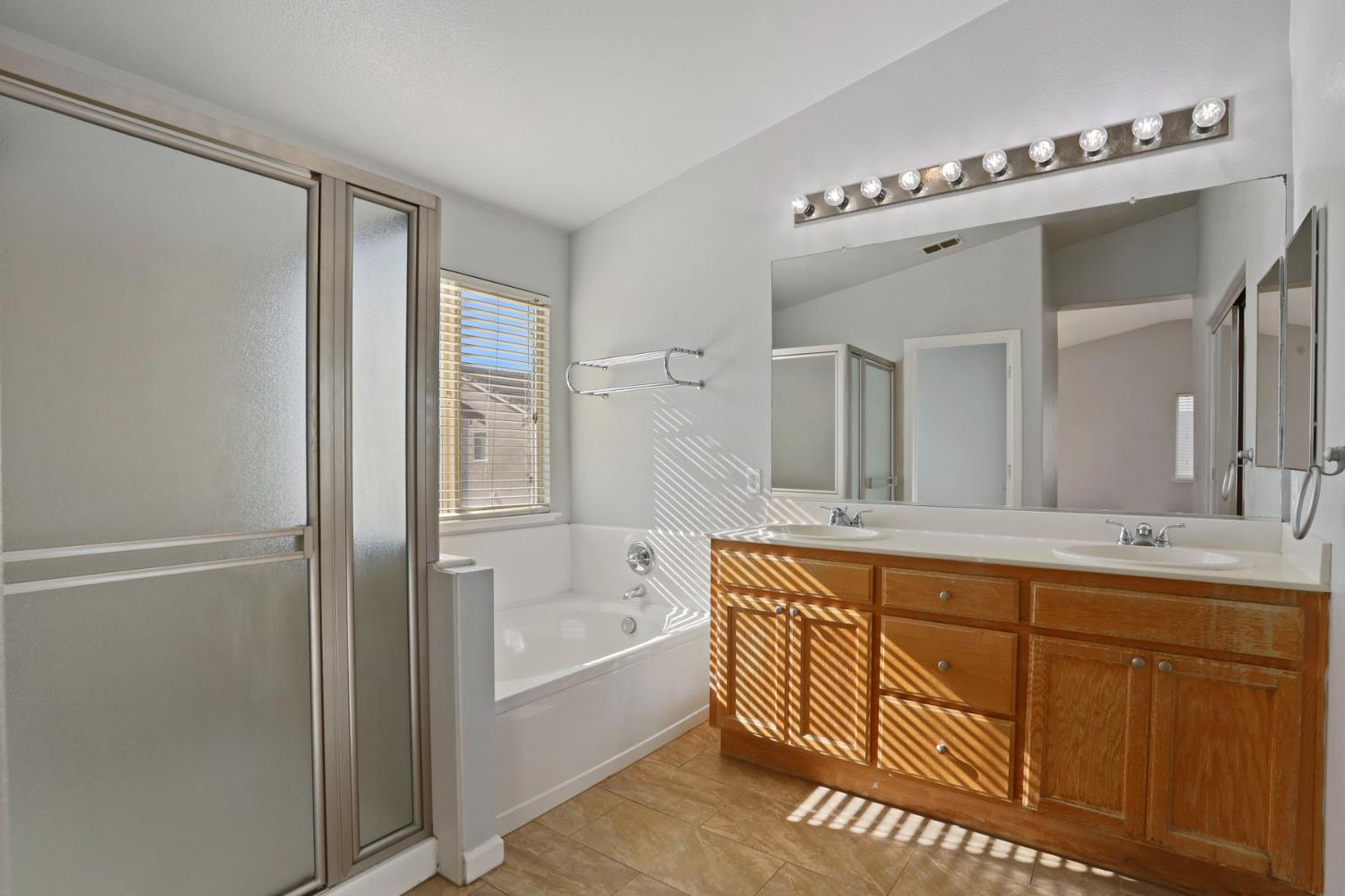 2902 Campbell Lane Tracy, CA 95377 - Photo 21 of 29 a bathroom with a tub a double vanity sink and mirror