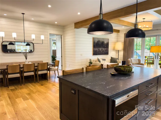 a kitchen with stainless steel appliances granite countertop a sink a stove and a wooden floors