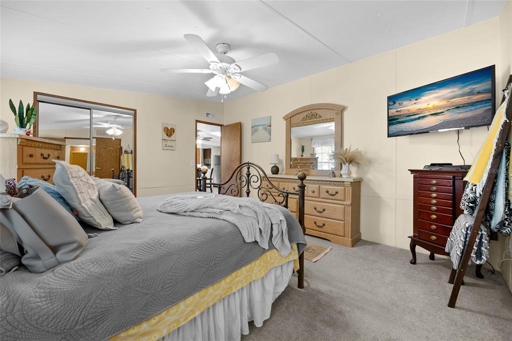 3639 Northeast 80th Avenue High Springs, FL 32643 - Photo 14 of 35 a bedroom with a bed a chandelier and dresser