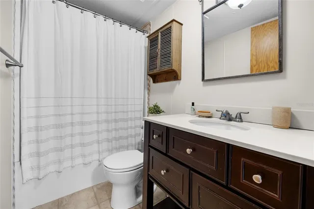 a bathroom with a granite countertop toilet sink and mirror