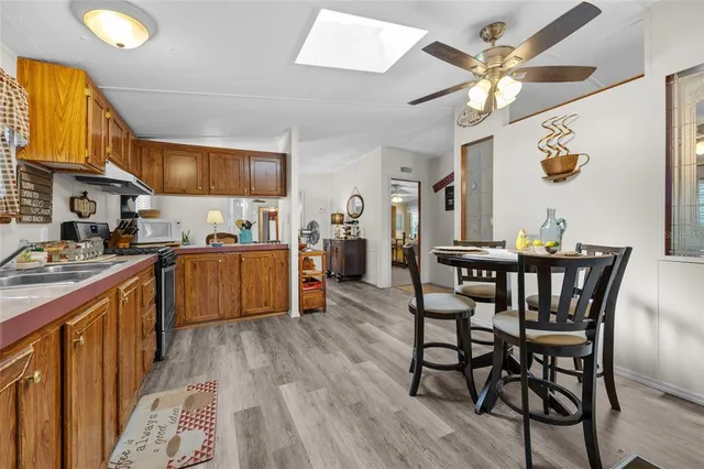 a kitchen with stainless steel appliances granite countertop wooden floor a dining table and chairs