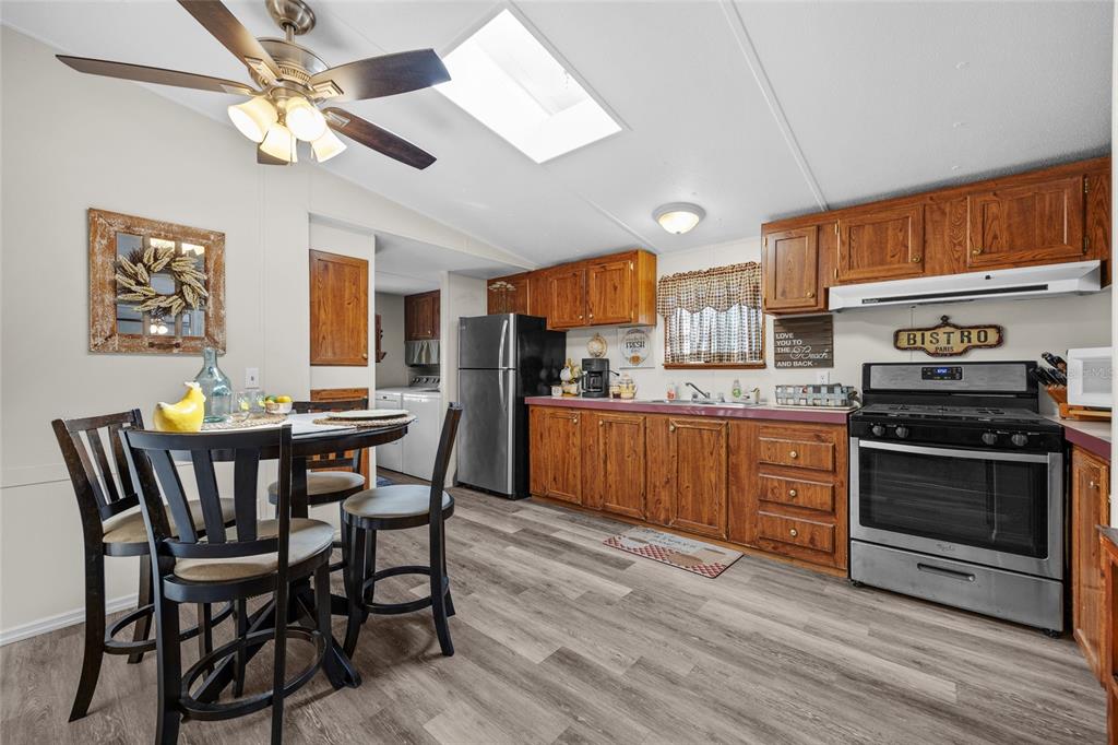 3639 Northeast 80th Avenue High Springs, FL 32643 - Photo 7 of 35 a kitchen with stainless steel appliances granite countertop a stove a sink dishwasher a dining table and chairs with wooden floor