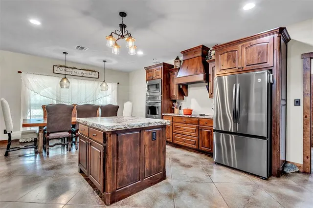 a kitchen with stainless steel appliances granite countertop a stove refrigerator and cabinets