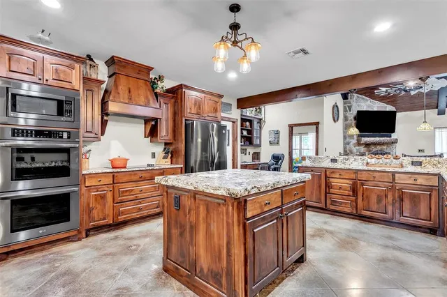 a kitchen with stainless steel appliances granite countertop a stove oven and a refrigerator