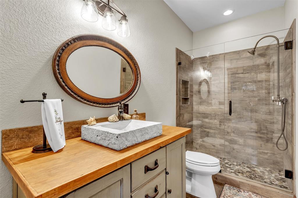 337 County Road 3535 Saltillo, TX 75478 - Photo 24 of 36 a bathroom with a granite countertop toilet a sink and a mirror