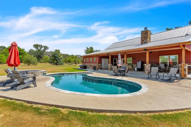 a view of swimming pool with seating area and barbeque oven