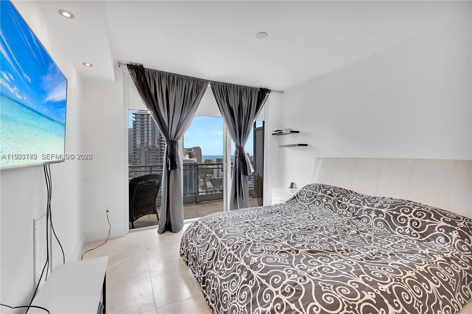 92 Southwest 3rd Street, Unit 3602 Miami, FL 33130 - Photo 5 of 11 a bedroom with a bed and a television