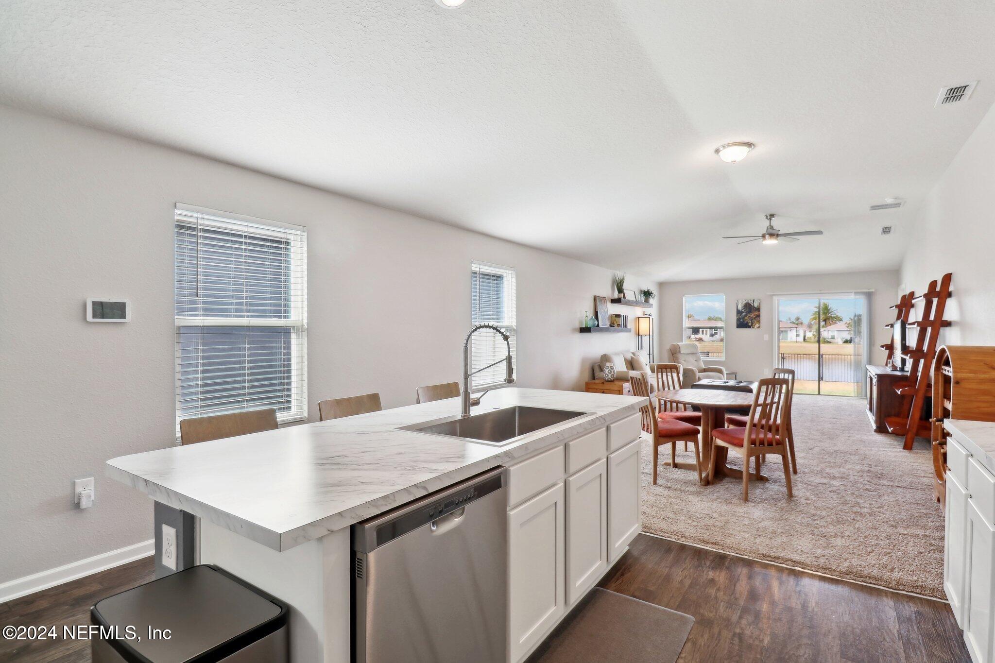 2535 Acorn Creek Road Green Cove Springs, FL 32043 - Photo 12 of 35 a living room with stainless steel appliances granite countertop a table chairs and a wooden floor