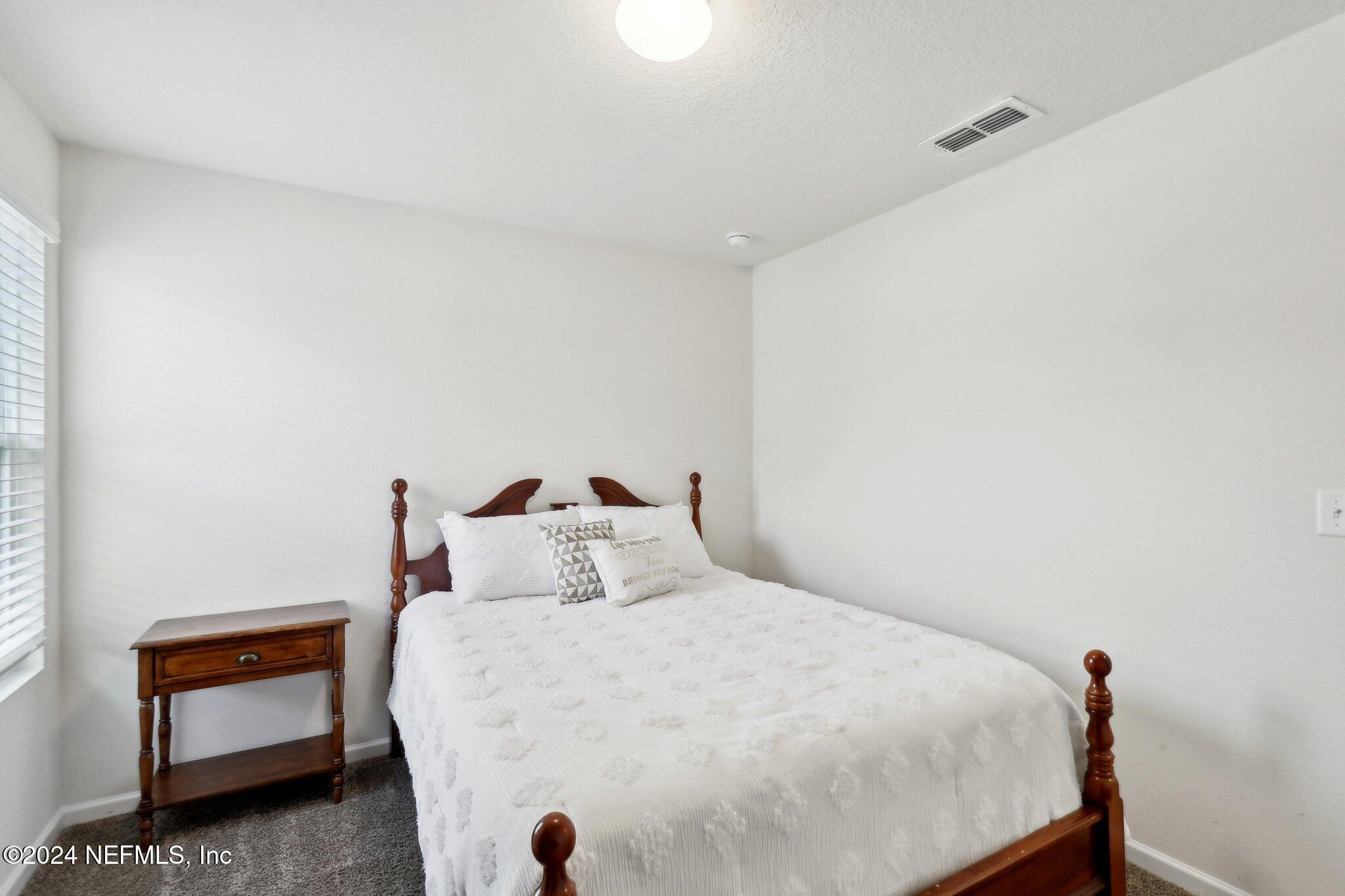 2535 Acorn Creek Road Green Cove Springs, FL 32043 - Photo 17 of 35 a bedroom with a bed and a lamp