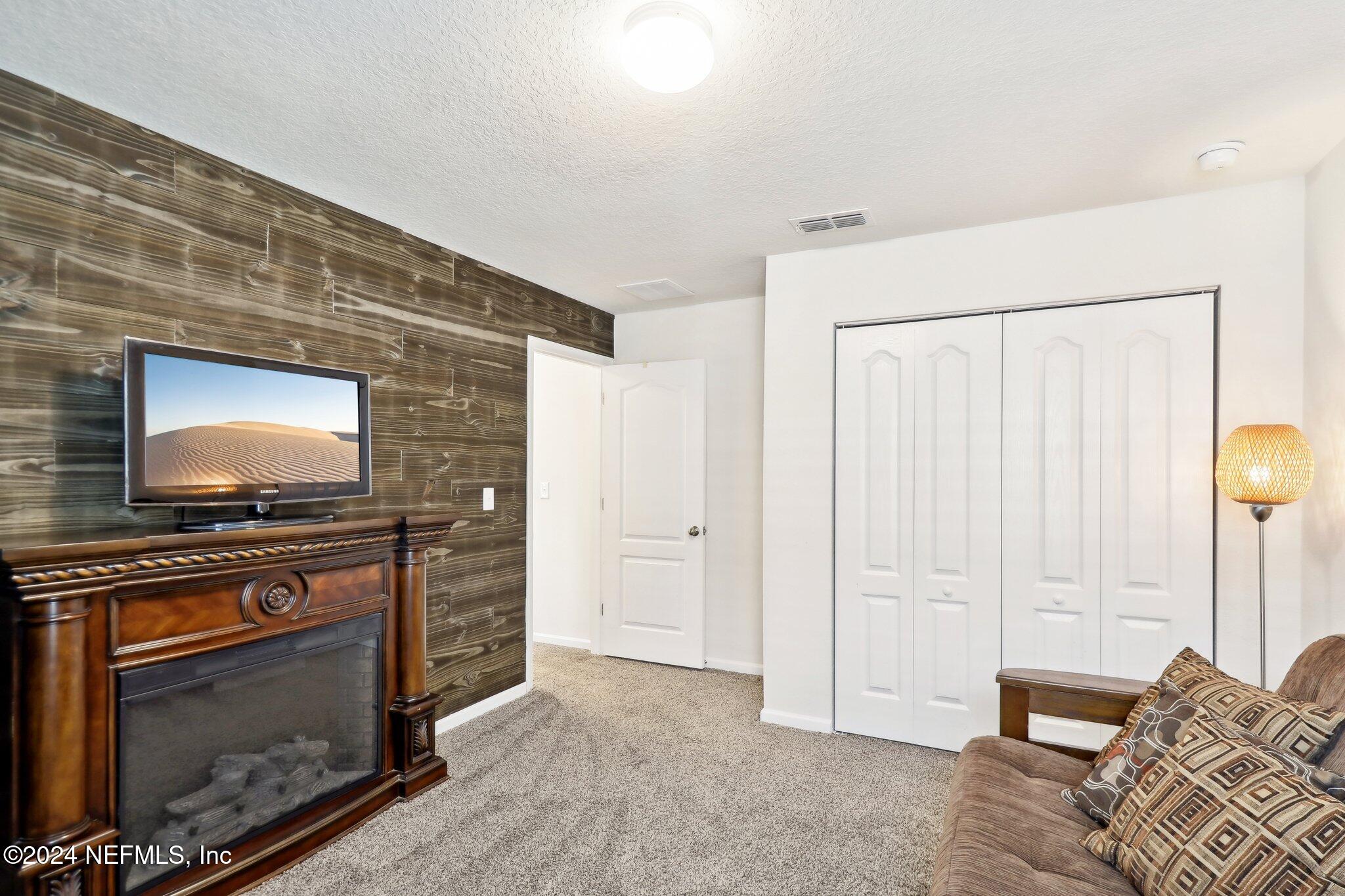 2535 Acorn Creek Road Green Cove Springs, FL 32043 - Photo 19 of 35 a living room with furniture a flat screen tv and a fireplace