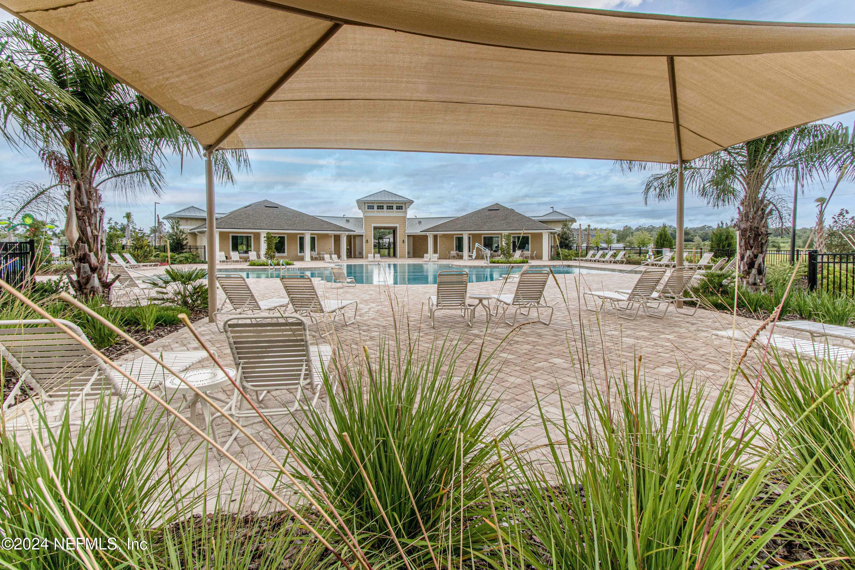 2535 Acorn Creek Road Green Cove Springs, FL 32043 - Photo 33 of 35 a view of a patio with table and chairs under an umbrella
