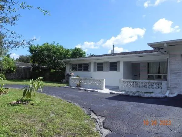 a view of a house with backyard and a tree