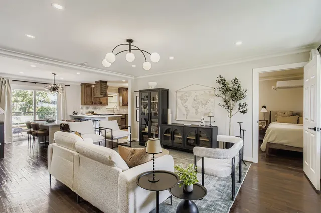 a living room with furniture kitchen view and a window