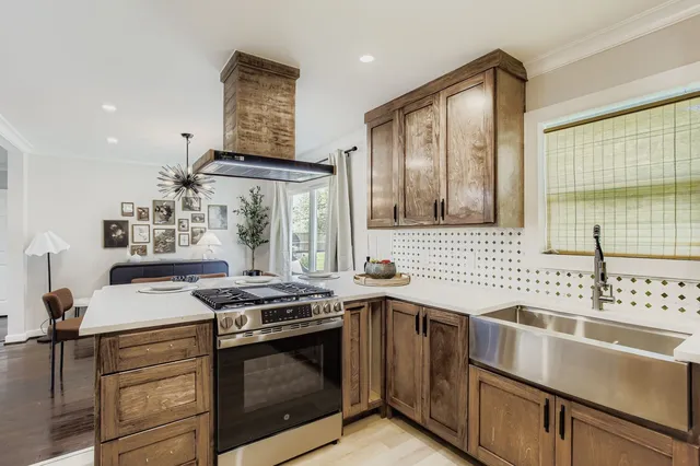 a kitchen with stainless steel appliances a stove a sink and a microwave
