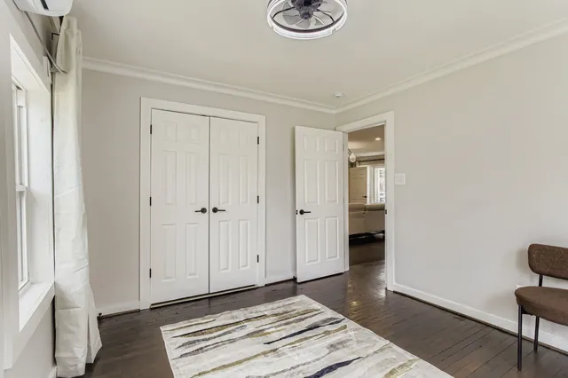 a view of a hallway with wooden floor and a window