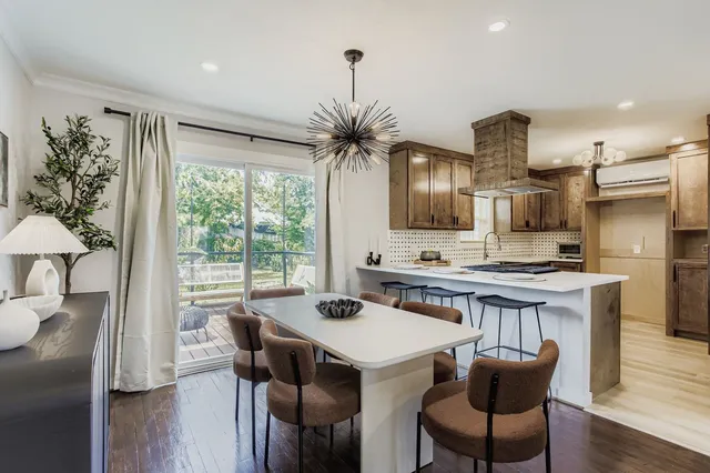 a kitchen with stainless steel appliances a table and chairs in it
