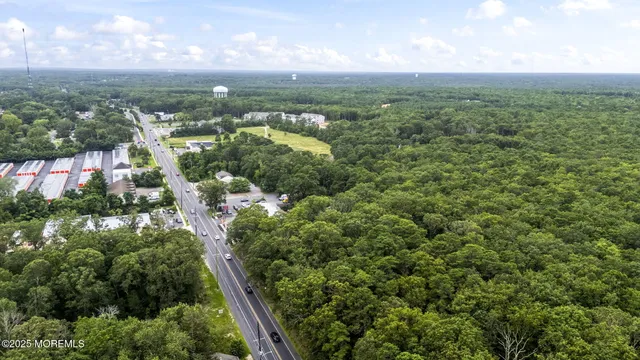 an aerial view of residential houses with outdoor space and trees