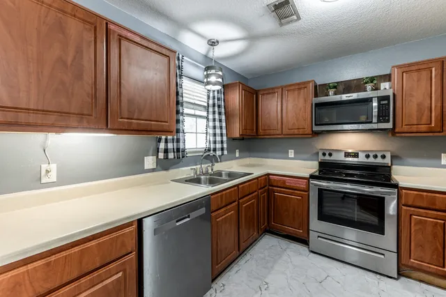 a kitchen with stainless steel appliances granite countertop a sink stove and microwave