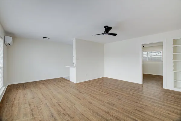 a view of empty room with wooden floor and ceiling fan